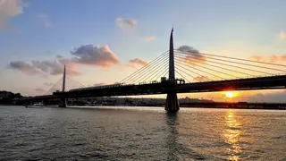 The Haliç Metro Bridge spans rippling water as the setting sun glows beneath its cable-stayed deck.