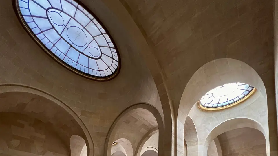 Arched stone ceilings are illuminated by two oval stained-glass skylights.
